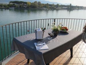 einen Tisch mit einer Schale Obst und Weingläsern in der Unterkunft Alla Foce del Magra - Villa sul fiume con posto barca vicino Cinque Terre in Ameglia