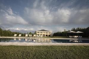 a pool with chairs and a house in the background at Estancia Mendoza Wine Hotel in Vista Flores