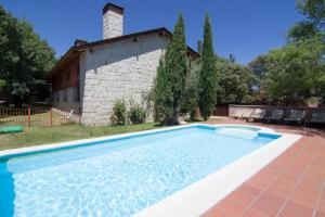 a swimming pool in front of a house at Hotel Sara De Ur in La Cabrera