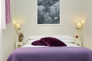 ローマにあるゲスト ハウス アマラント ロマーノのベッドルーム(紫色の枕付きのベッド1台付)