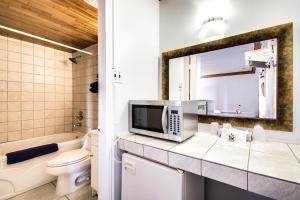 a bathroom with a toilet and a microwave on a counter at Motel Bellefeuille in Trois-Rivières