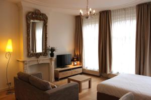 ein Hotelzimmer mit einem Bett, einem Stuhl und einem Spiegel in der Unterkunft Amsterdam Jewel Canal Apartments in Amsterdam
