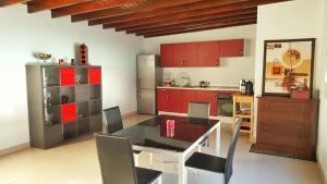 NazaretにあるVilla Nazolyのキッチン(赤いキャビネット、テーブル、椅子付)