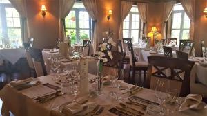 un comedor con mesas y sillas con manteles blancos en L'Oasis de l'Île en Saint-Eustache