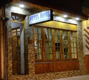 TocopillaHOTEL ROYAL的带有车库并挂有标志的建筑