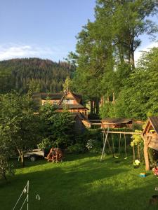 a yard with a house and a swing at Figusówka in Zakopane