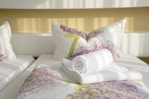 a bed with towels and purple flowers on it at Hotel Bliesbrück in Herbitzheim