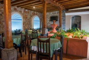 a dining room with tables and chairs and a television at Hotel Casa de las Fuentes in Antigua Guatemala
