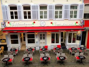 un restaurante con mesas y sillas frente a un edificio en C'est la vie Ferienapartments, en Saarlouis