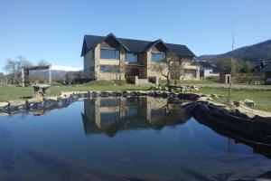 a house sitting on top of a body of water at Hostería La Chira in San Martín de los Andes