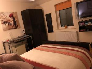 a bedroom with a bed and a flat screen tv at Elm Grove in Schull