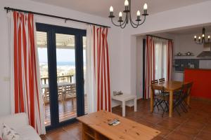 a living room with a table and a view of a balcony at Paradisia Villas in Naxos Chora