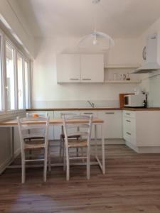 Una cocina con gabinetes blancos y una mesa y sillas. en 6A, en Aviñón