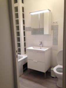 Un baño con lavabo, inodoro y espejo. en 6A, en Aviñón