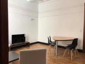 a room with a table and two chairs and a tv at Antiguo departamento con excelente ubicación in Buenos Aires