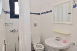 a white bathroom with a toilet and a sink at Paradisia Villas in Naxos Chora