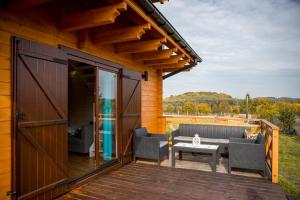 a deck with chairs and a table on a house at Na Dworosku in Golczowice +11 photos