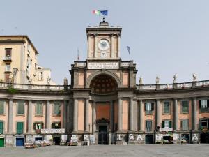 un edificio con una torre dell'orologio sopra di Foro Carolino S&B a Napoli