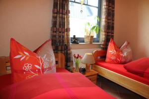1 Schlafzimmer mit 2 roten Betten und einem Fenster in der Unterkunft Ferienwohnung Baumann in Prerow
