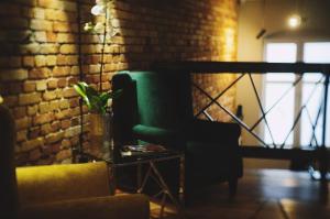 扎雷ApartHotel I SORAU的客厅设有绿色椅子和砖墙