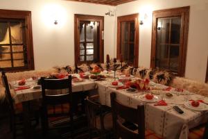 een eetkamer met een lange tafel met witte tafellaken bij Къща за гости Гайтана in Shiroka Lŭka