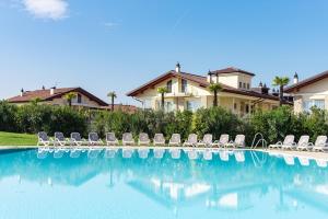 a group of chairs sitting next to a swimming pool at Casa di Alex | Sirmione in Sirmione