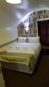 een slaapkamer met een bed en een raam met boeken bij Portsmouth Budget Hotels - All rooms are EN-SUITE in Portsmouth