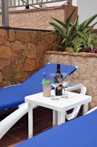 Casa Marinero with Private Pool في بويرتو ديل روزاريو: طاولة بيضاء مع كؤوس للنبيذ وكرسي أزرق