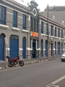 a motorcycle parked in front of a building with blue doors at Hotel Michel in São Paulo