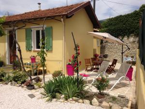 een huis met een patio met stoelen en een parasol bij Le 43 in La Trinité