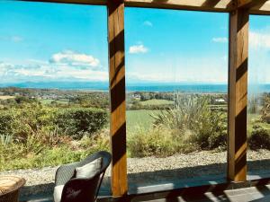 a view of the ocean from the porch of a house at The Piggery - North Wales Retreat in Pwllheli