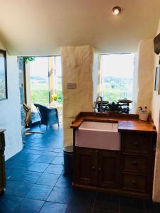 een keuken met een wastafel en een groot raam bij The Piggery - North Wales Retreat in Pwllheli