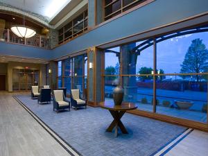 een lobby met een tafel, stoelen en ramen bij Bally's Evansville Casino & Hotel in Evansville