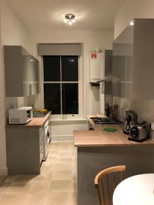 ロンドンにあるSt Julian’s Road Apartmentのキッチン(シンク、コンロ付)、窓が備わります。