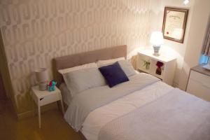 a bedroom with a white bed with a blue pillow at Thames View Apartments in London
