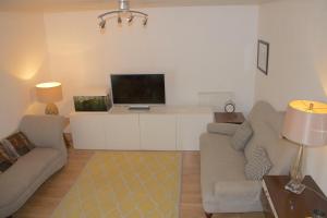 a living room with a couch and a flat screen tv at Thames View Apartments in London