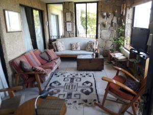 a living room with a couch and chairs and a tv at B&B Santo Domingo Chile ENGLISH SPOKEN Gran Departamento compartido frente al mar PARQUE TRICAO bird sanctuary 14kms 9miles away DESAYUNO ESTACIONAMIENTO Y WIFI GRATIS Free parking wifi and breakfast in Santo Domingo