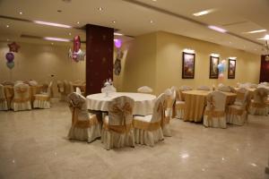 ein Bankettsaal mit Tischen und Stühlen in einem Raum in der Unterkunft Western Gate Residence 2 Amman in Amman