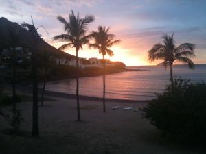 a sunset on a beach with palm trees at Hotel Playa de Cortes in Guaymas
