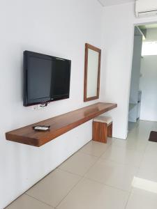 a flat screen tv on a wall in a room at Hotel Ariandri Puncak in Puncak