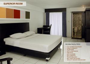 a bedroom with a bed and a desk at Hotel Ariandri Puncak in Puncak