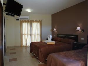 Habitación de hotel con 2 camas y TV de pantalla plana. en Apart Hotel Vista San Lucas en Carpintería