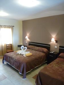 una camera d'albergo con due letti con cigni di Apart Hotel Vista San Lucas a Carpintería