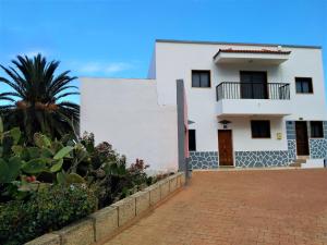 una casa blanca con una palmera delante de ella en Casa Fasnia Nature, en Fasnia