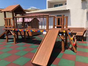 un parque infantil de madera con un tobogán en un patio en Le Bon Vivant 307 B, en Arraial do Cabo