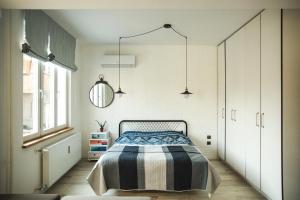 - une chambre avec un lit et une couverture rayée dans l'établissement Sunny studio on ulica Lyuben Karavelov, à Sofia