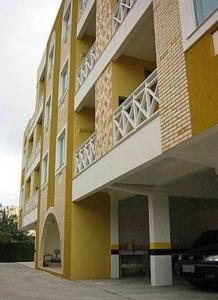 um edifício amarelo com um carro estacionado ao lado em Residencial Solar Bela Vista em Florianópolis