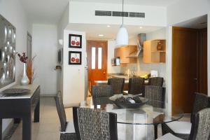 a dining room and kitchen with a glass table and chairs at Condo Mayan Lakes in Acapulco