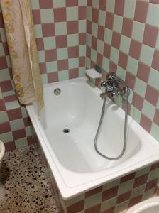 a bath tub with a shower in a bathroom at Hostel Alhambra in Girona
