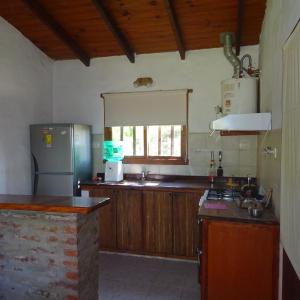 cocina con nevera y encimera en casa barrio golf en Tandil